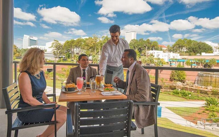 diners served at table overlooking park with waterfall fountain at the edison tallahassee