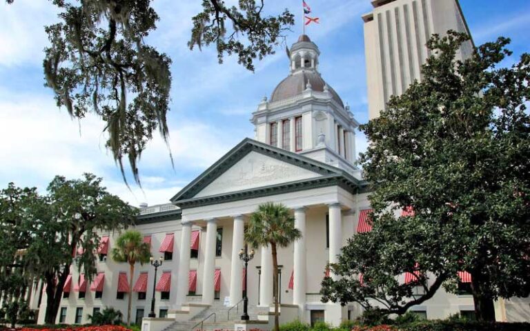 exterior of neoclassical building with striped awnings and dome at florida historic capitol museum tallahassee