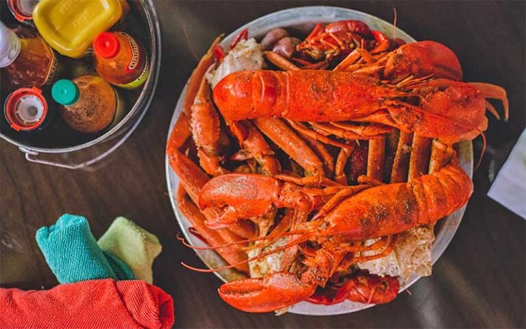 lobsters and crab legs in pot on tabletop with sauces at wahoo seafood grill tallahassee