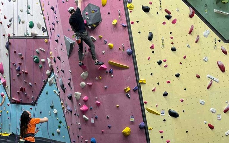 man climbing wall with woman spotting at alchemy climbing tallahassee