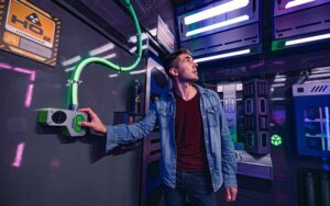 man pressing button in space ship room for cosmic crisis at the escape game