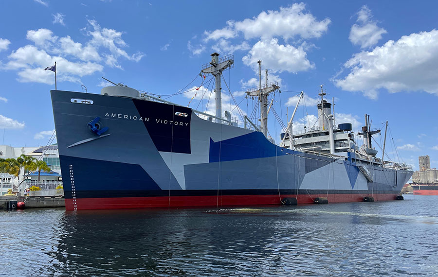 military war ship with blue paneled paint docked in bay american victory ship museum tampa