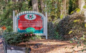 red park sign with camelia in shady garden spot at dorothy b oven park tallahassee