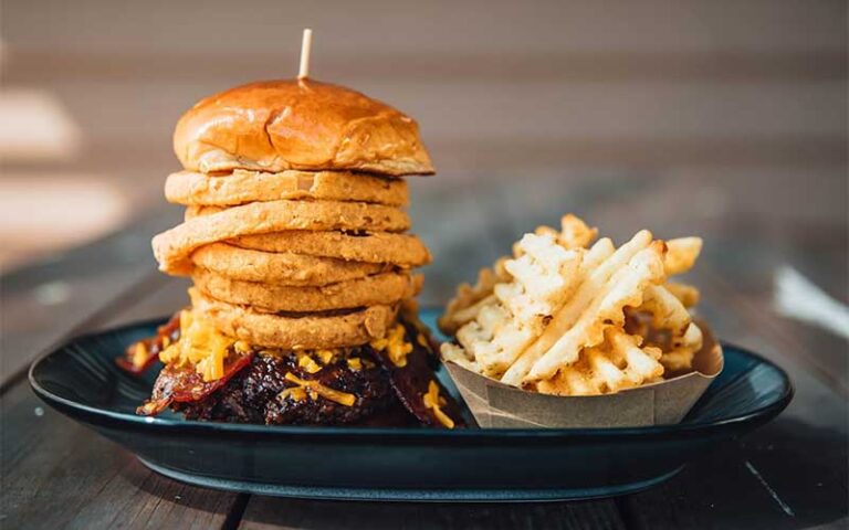 stacked onion rings burger with waffle fries at walk ons sports bistreaux lakeland