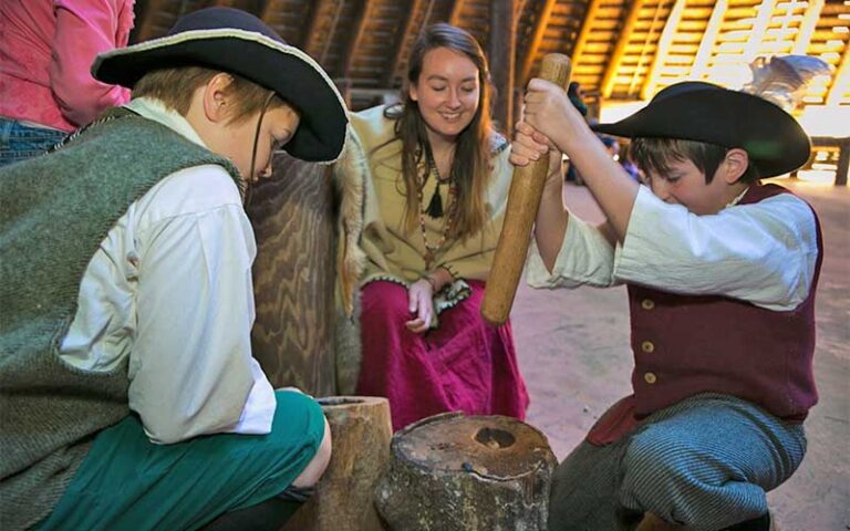 young men in period costume using old tools at mission san luis tallahassee