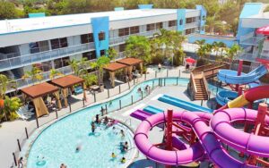 aerial view of hotel with balconies pool with people and water slide at flamingo waterpark resort kissimmee