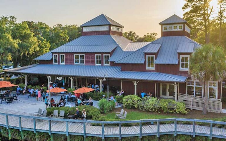 aerial view of restaurant with patio seating on boardwalk facing water feature at marche burette omni amelia island