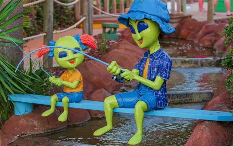 alien statues fishing in water feature at ufo golf pensacola beach