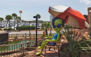 alien sunbather figure on golf course with watertower in background at ufo golf pensacola beach