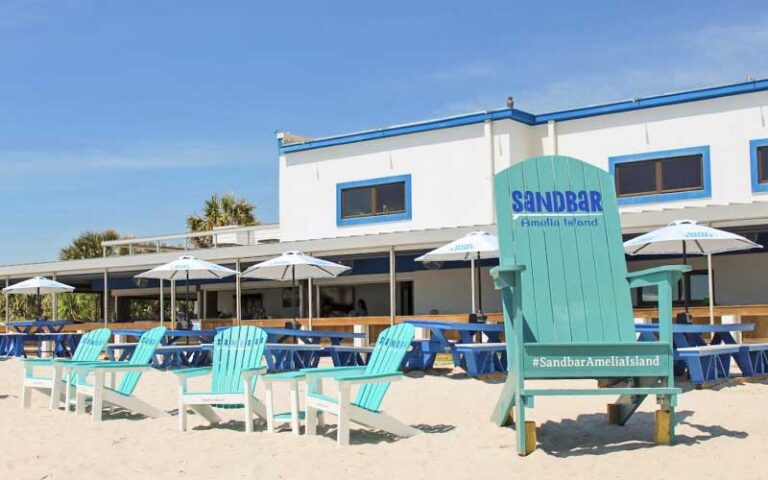 blue and white restaurant on beach with seating and giant chair at sandbar amelia island fernandina beach