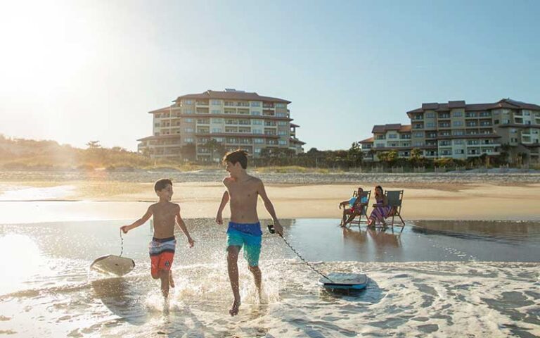 boys running into surf on beach at the villas of amelia island fernandina beach