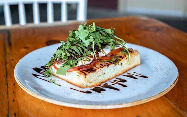 bread with caprese salad and balsamic vinegar on plate tabletop at marche burette omni amelia island