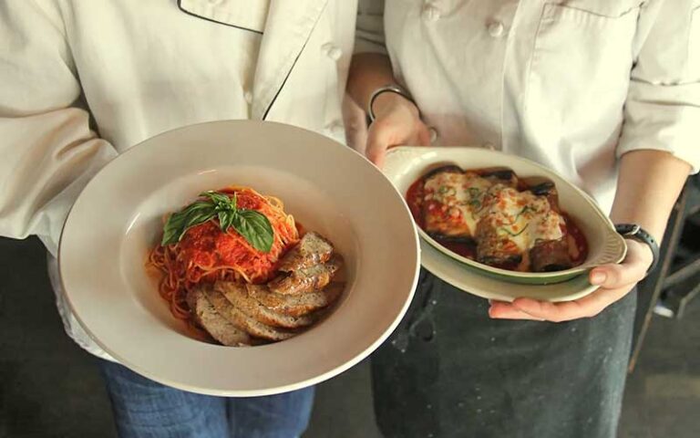 chefs holding pasta entrees at bella bella tallahassee