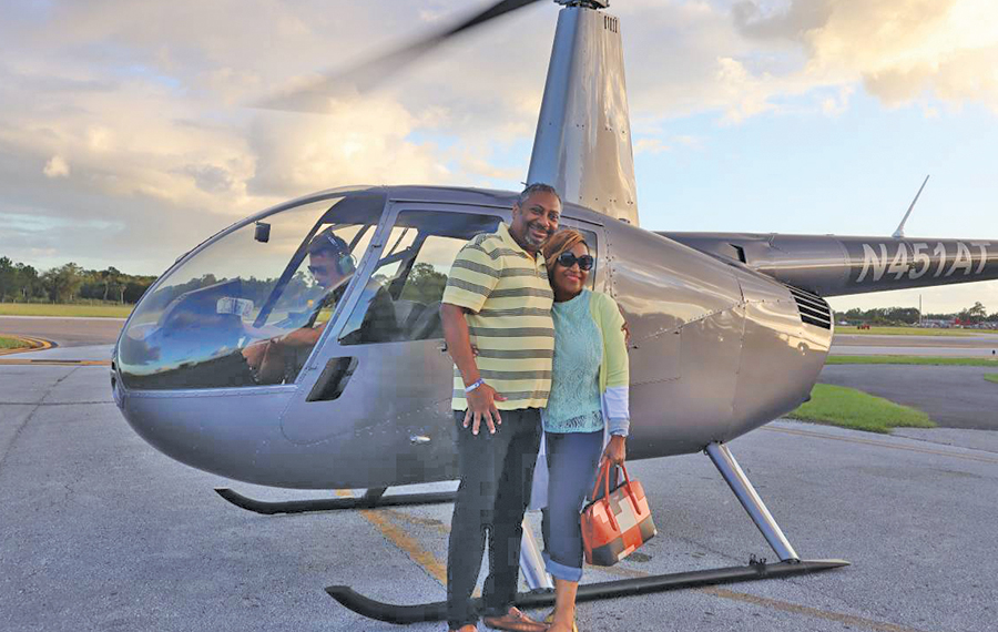 couple embracing in front of helicopter before flight at maxflight helicopter services kissimmee