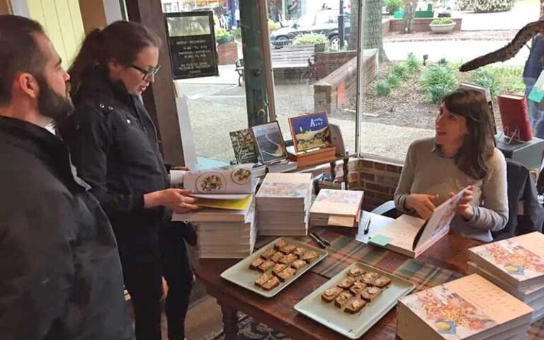 couple getting author to sign book at table at the book loft fernandina beach amelia island