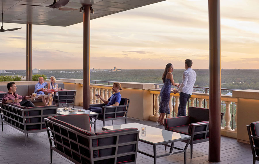 couple talking on rooftop terrace dining area with panoramic views at four seasons orlando resort