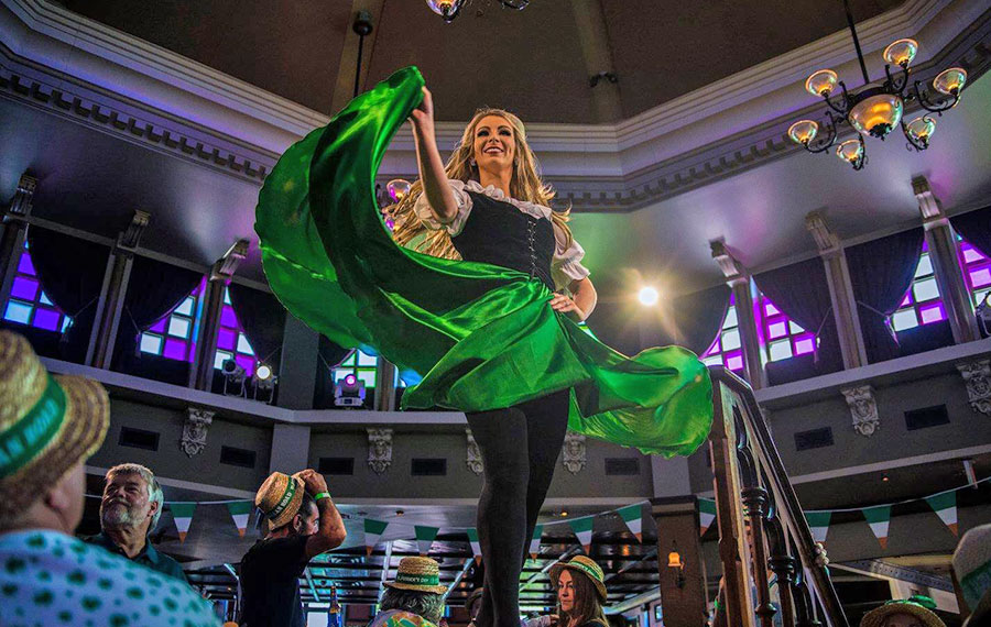 dancer with green dress on stage with diners in green hats around at raglan road irish pub disney springs