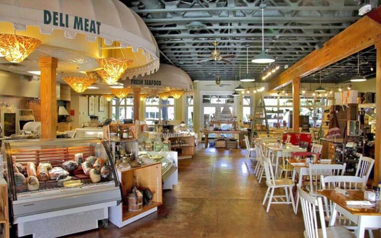 dining area interior with deli cases and seating at marche burette omni amelia island