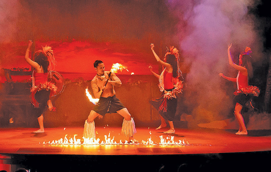 fire dancer with hula dancers performing on stage at polynesian fire luau orlando