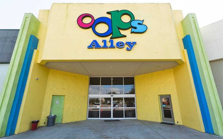 front entrance of building with colorful sign at oops alley family entertainment center pensacola