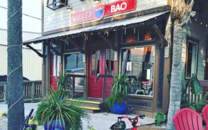 front exterior of cafe with sign and palms at wicked bao fernandina beach amelia island