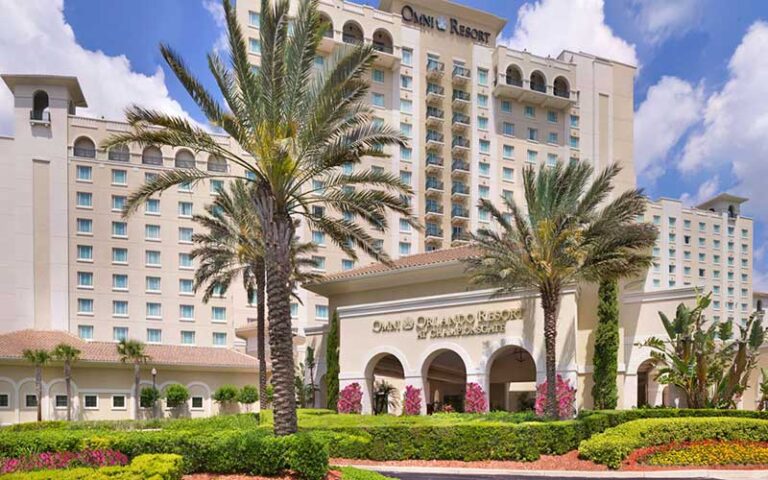 front exterior of high rise hotel with palms and sign at omni orlando resort at championsgate