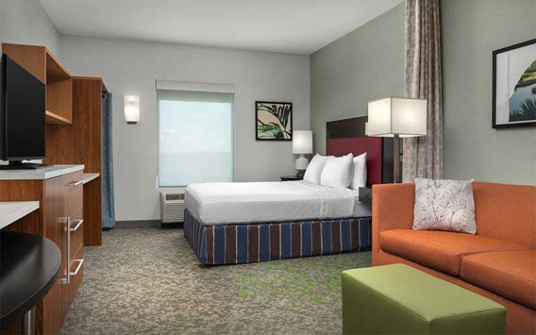 king size bed and sofa in suite at home2 suites by hilton tallahassee state capital