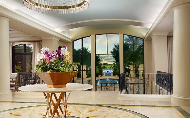 lobby with columns and view of fountain outside at omni orlando resort at championsgate