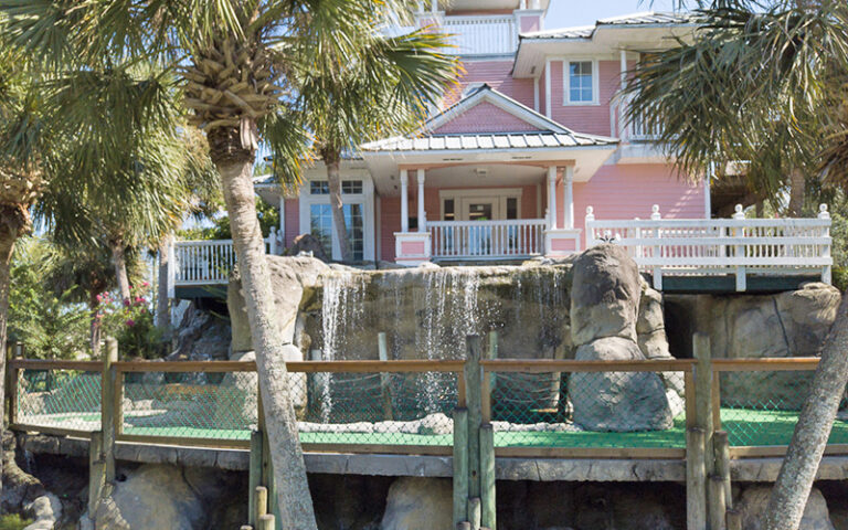 mini golf hole with pink house and trees at island falls adventure golf amelia island