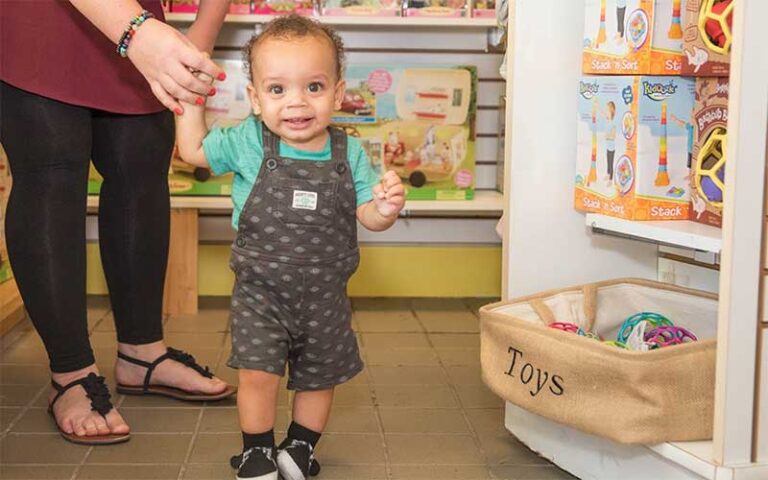 mom with toddler near toy shelf at villa villekulla neighborhood toy store fernandina beach amelia island