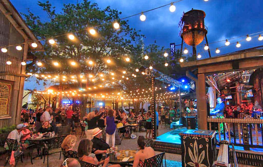 outdoor dining area at night with live band string lights and water tower at house of blues disney springs