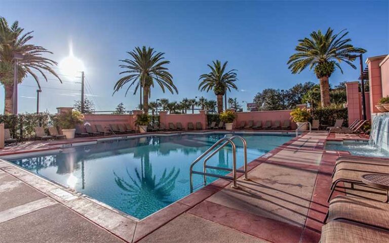 outdoor pool deck with palms and sun at embassy suites by hilton orlando lake buena vista south kissimmee