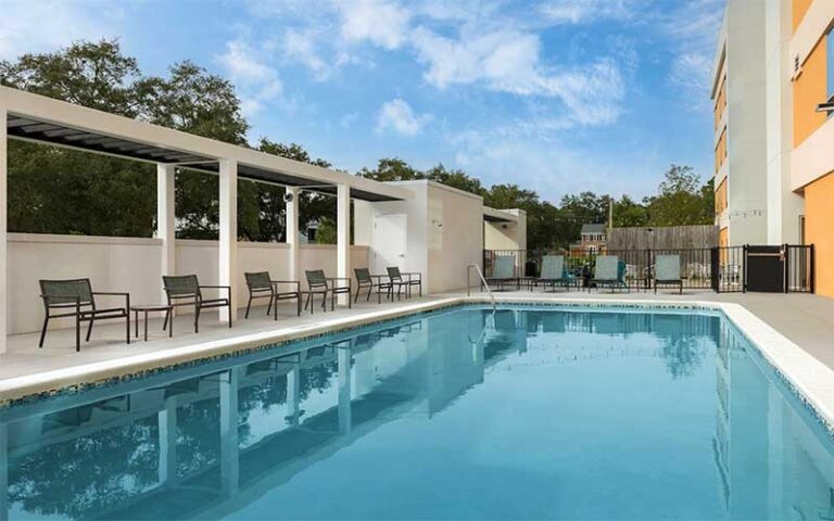 outdoor pool with blue sky and seating at home2 suites by hilton tallahassee state capital