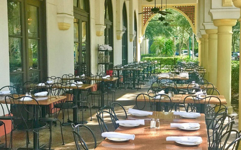 outdoor veranda dining area with yellow columns at columbia restaurant celebration kissimmee