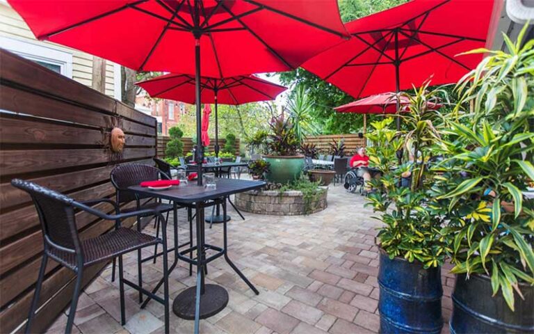 patio dining with red umbrellas and plants at espana restaurant tapas fernandina beach amelia island