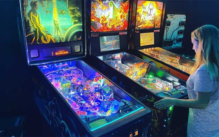 pinball machines with girl playing at the grid arcade pensacola