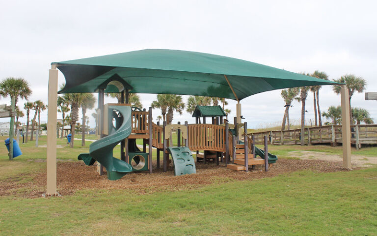 playground under shady canopy in grassy area at main beach park fernandina amelia island