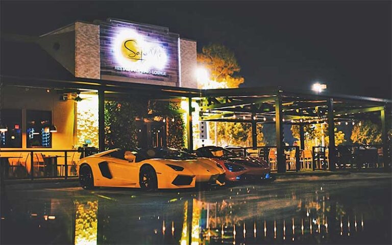 restaurant night exterior with patio seating and exotic cars at sajoma latin fusion kissimmee