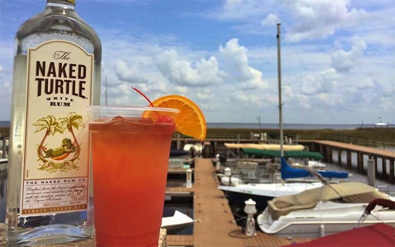 rum bottle and cocktail with marina and sky background at crabby bills st cloud kissimmee