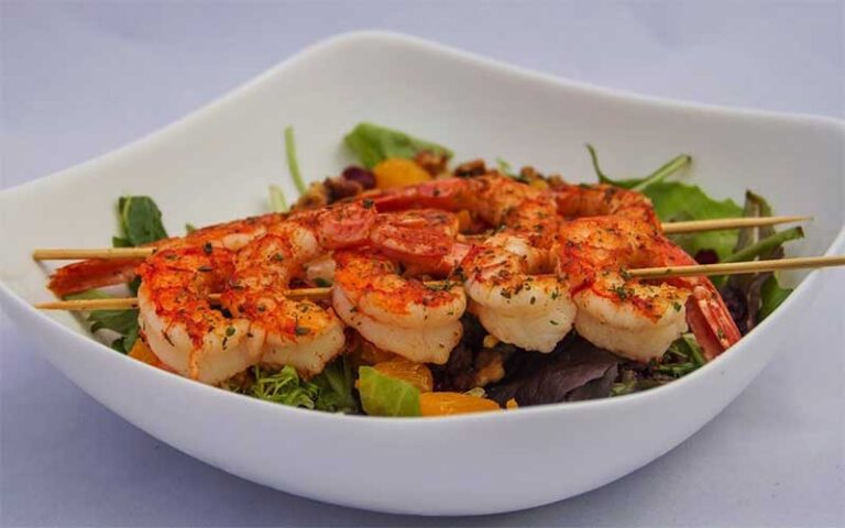 spiced shrimp on skewers over salad bowl at crabby bills st cloud kissimmee