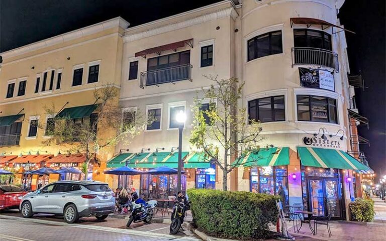 street block with restaurant on corner at night at 3 sisters speakeasy kissimmee