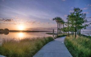sunset over lake with walkway leading to lighthouse statue at kissimmee lakefront park