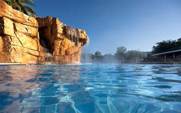 swimming pool with waterfall over rocks at hilton vacation club mystic dunes orlando celebration