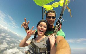 tandem jump with girl yellow chute and clouds at skydiving jacksonville amelia island