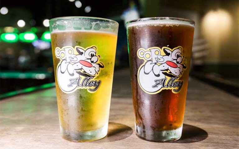 two glass pints of beer with branding at oops alley family entertainment center pensacola