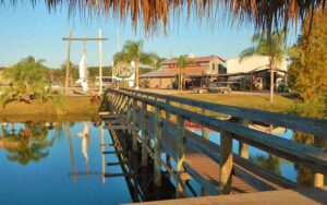 view across water with foot bridge of farm with big fish hanging sign at showcase of citrus clermont kissimmee