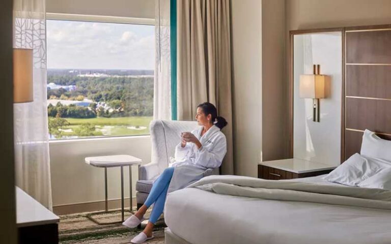 woman with coffee in king suite with view at signia by hilton orlando bonnet creek