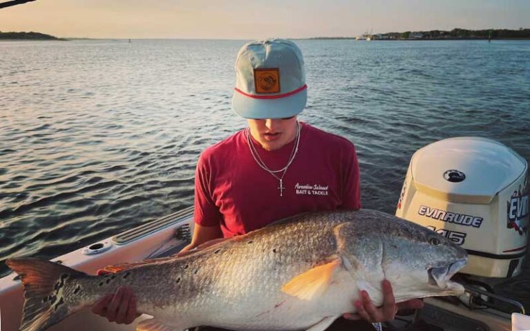 young man on boat holding huge fish at amelia island bait tackle fernandina beach