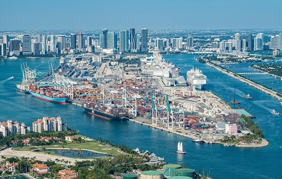 aerial view of cruise ships and cargo cranes at portmiami with skyline