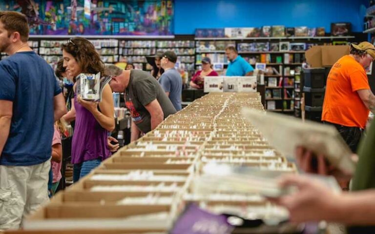 crowds of customers looking through stacks at bearded browncoat comics games ocala